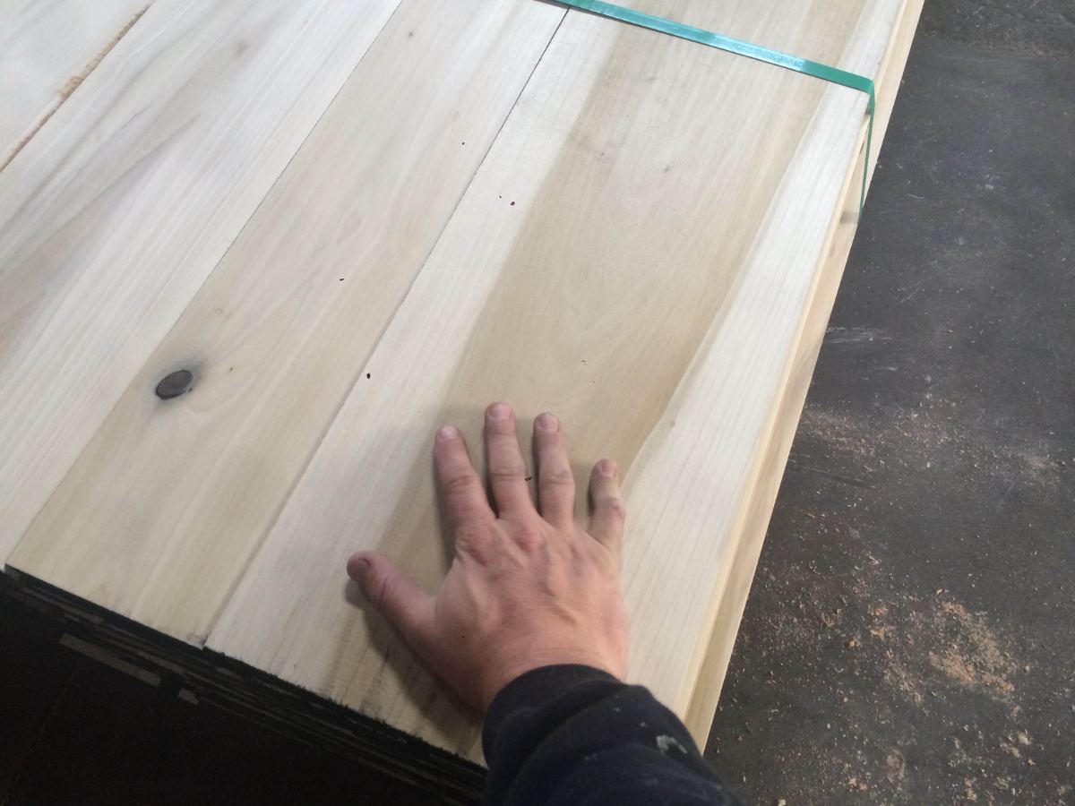 A hand across freshly milled boards